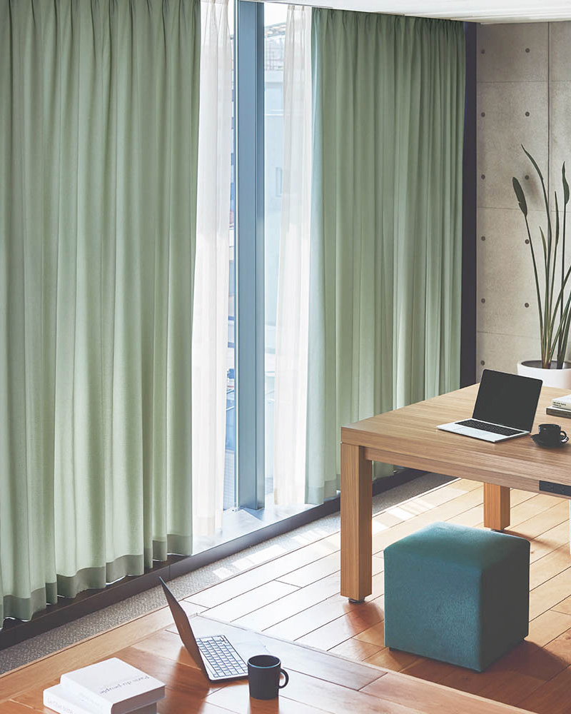 緑のカーテンと木目調の家具の写真